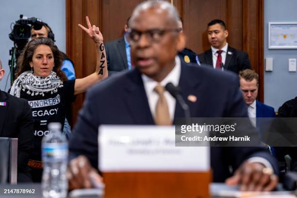 Protester from the group Code Pink holds up her arm with the word "Gaza" written on it as U.S. Secretary of Defense Lloyd Austin speaks at a House...