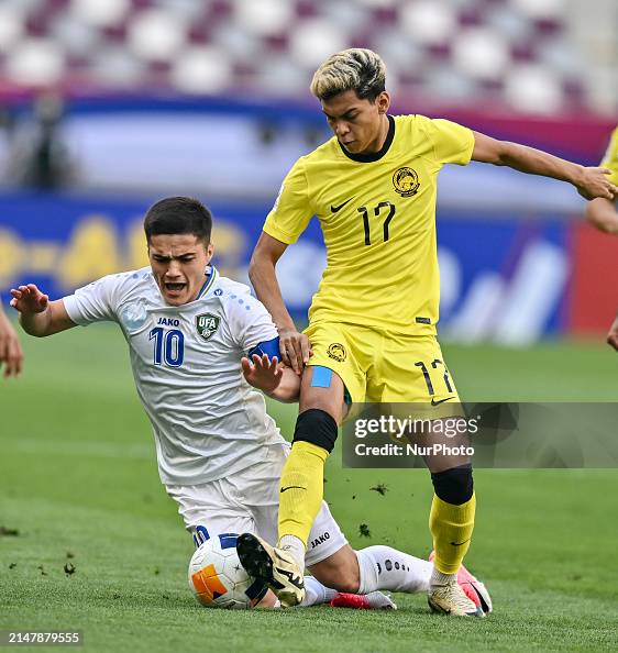 Jasurbek Jaloliddinov of Uzbekistan is battling for the ball with