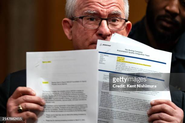 Activist Daryl Guberman holds up papers he asks chairman Sen. Richard Blumenthal to accept evidence as he interrupts a Senate Homeland Security and...