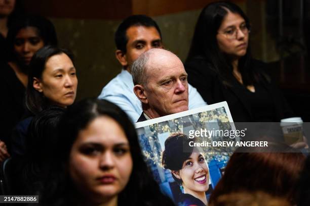 Chris Moore holds a photo of his daughter Danielle Moore, who died in the crash of Ethiopian Airlines flight 302, during a US Senate Homeland...