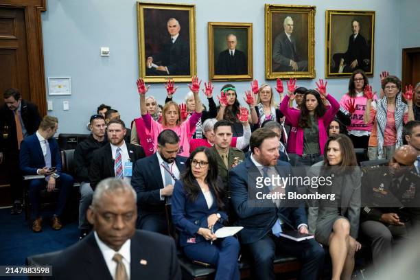 Protesters raise their hands as Lloyd Austin, US secretary of defense, left, arrives for a House Appropriations Subcommittee on Defense hearing in...