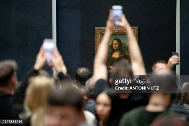 Visitors take pictures of Leonardo Da Vinci's "Mona Lisa" painting, at the Louvre Museum, in Paris, on April 17, 2024.