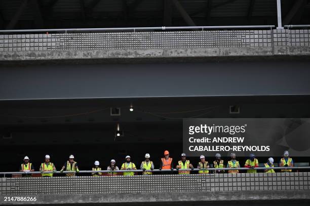 Construction workers gather to watch US President Joe Biden during a visit at a modernization project at Pittsburgh International Airport in...