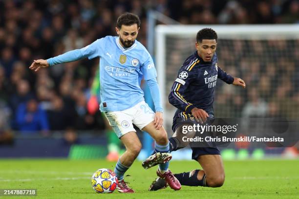 Jude Bellingham of Real Madrid competes with Bernardo Silva of Manchester City during the UEFA Champions League quarter-final second leg match...