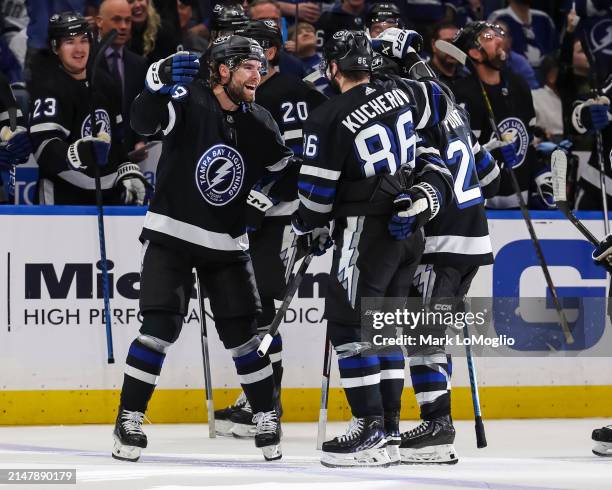 Nikita Kucherov of the Tampa Bay Lightning celebrates his 100th assist on the season with Brandon Hagel and Brayden Point against the Toronto Maple...