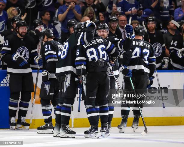 Nikita Kucherov of the Tampa Bay Lightning celebrates his 100th assist on the season with Brandon Hagel, Steven Stamkos, Darren Raddysh, and Brayden...