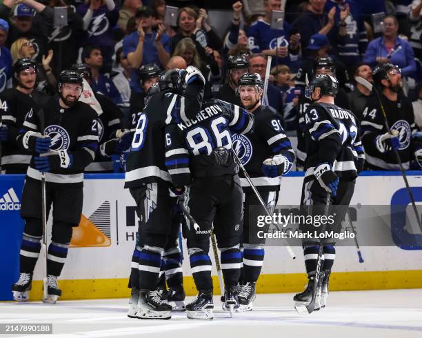 Nikita Kucherov of the Tampa Bay Lightning celebrates his 100th assist on the season with Brandon Hagel, Steven Stamkos, Darren Raddysh, and Brayden...