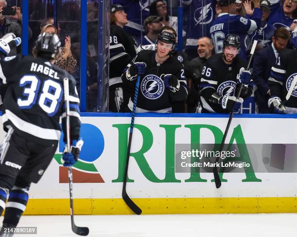 Nikita Kucherov and Brayden Point of the Tampa Bay Lightning celebrate a goal by teammate Brandon Hagel against the Toronto Maple Leafs during the...