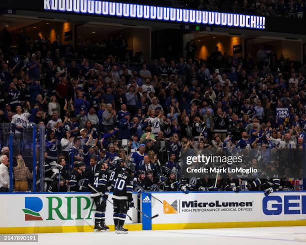 Nikita Kucherov of the Tampa Bay Lightning celebrates his 100th assist on the season with teammates against the Toronto Maple Leafs during the second...