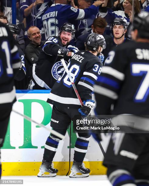 Nikita Kucherov and Brayden Point of the Tampa Bay Lightning celebrate a goal by teammate Brandon Hagel against the Toronto Maple Leafs during the...