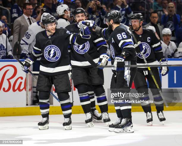 Nikita Kucherov of the Tampa Bay Lightning celebrates his 100th assist on the season with teammates against the Toronto Maple Leafs during the second...