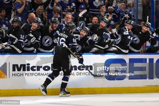 Nikita Kucherov of the Tampa Bay Lightning celebrates his 100th assist on the season with teammates against the Toronto Maple Leafs during the second...