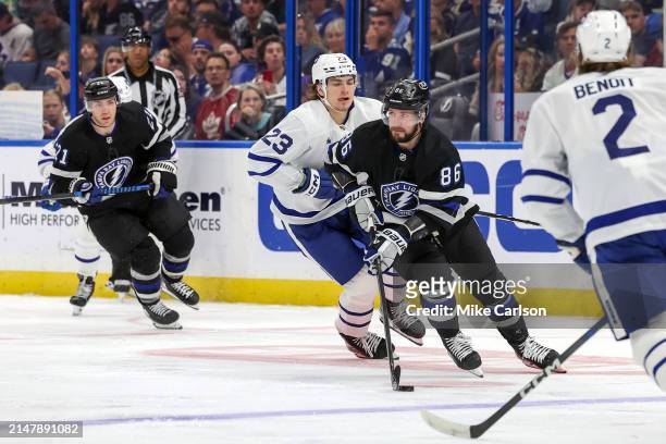 Nikita Kucherov of the Tampa Bay Lightning skates past Matthew Knies of the Toronto Maple Leafs during the second period at the Amalie Arena on April...