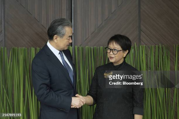 Wang Yi, China's foreign minister, left, and Retno Marsudi, Indonesia's foreign affairs minister, shake hands as they meet in Jakarta, Indonesia, on...