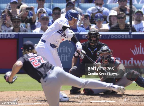 Shohei Ohtani of the Los Angeles Dodgers hits a single against Washington Nationals starting pitcher Jake Irvin in the sixth inning of a baseball...