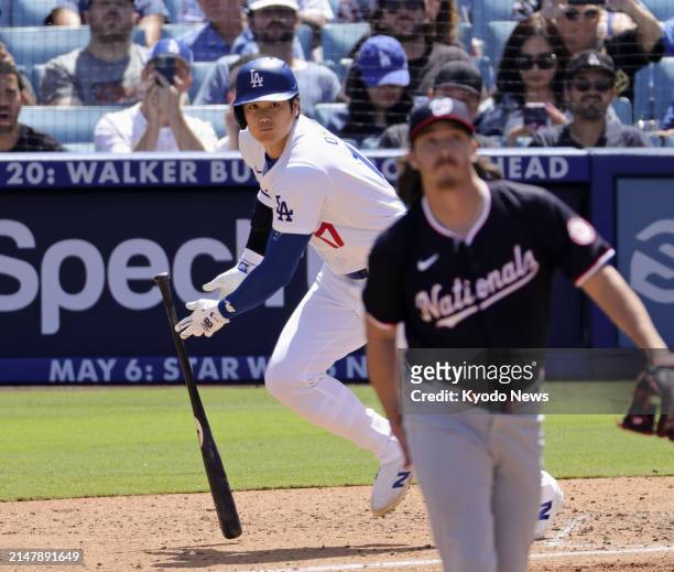 Shohei Ohtani of the Los Angeles Dodgers hits a single against Washington Nationals pitcher Hunter Harvey in the eighth inning of a baseball game on...