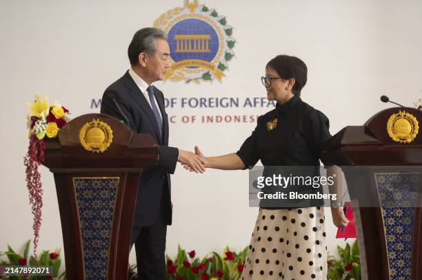 Wang Yi, China's foreign minister, left, and Retno Marsudi, Indonesia's foreign affairs minister, shake hands during a news conference in Jakarta,...