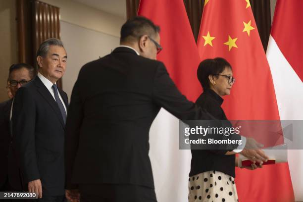 Wang Yi, China's foreign minister, left, and Retno Marsudi, Indonesia's foreign affairs minister, right, arrive for a news conference in Jakarta,...