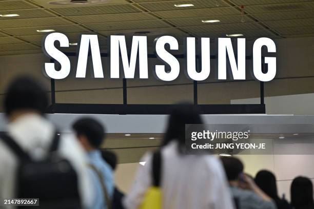 Visitors walk past the logo of Samsung Electronics during the 2024 World IT Show in Seoul on April 18, 2024.