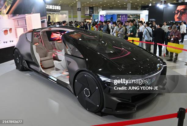 Visitors look at a concept car for LG Electronics' next-generation mobility vision of "Alpha-able" during the 2024 World IT Show in Seoul on April...