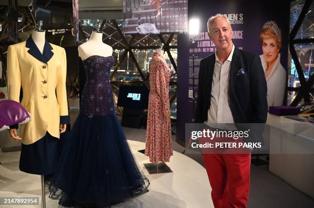 Photo taken on April 17, 2024 shows Martin Nolan, Co-Founder and Executive Director of Julien's Auctions, standing next to dresses once worn by...