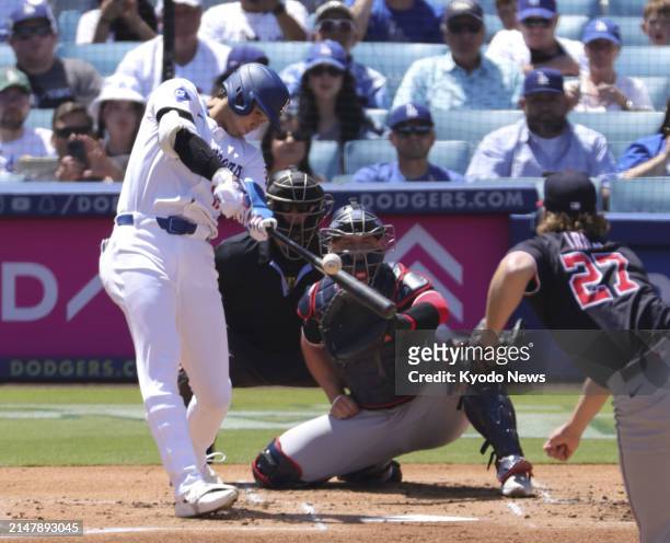 Shohei Ohtani of the Los Angeles Dodgers hits a single against Washington Nationals starting pitcher Jake Irvin in the first inning of a baseball...
