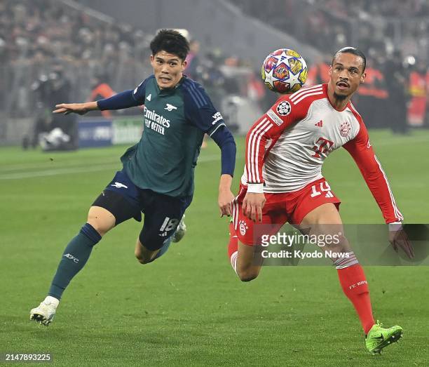 Arsenal's Takehiro Tomiyasu and Bayern Munich's Leroy Sane vie for the ball in the first half of a Champions League quarterfinal match on April 17 in...