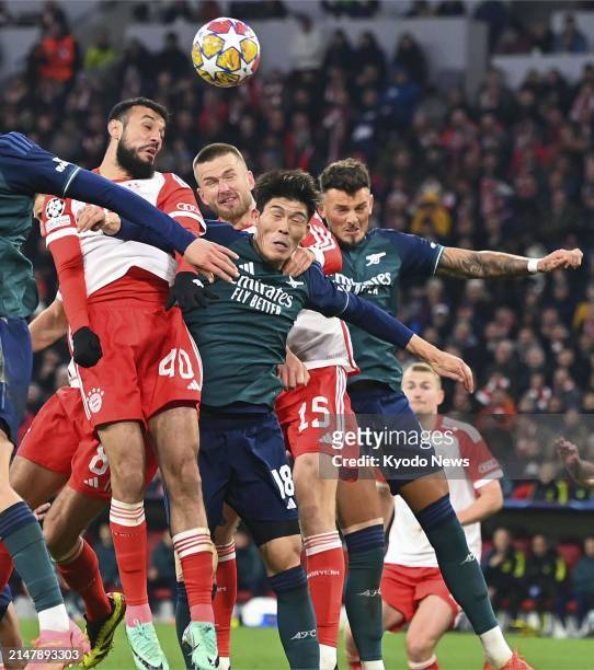 Arsenal's Takehiro Tomiyasu is challenged by Bayern Munich players in the second half of a Champions League quarterfinal match on April 17 in Munich.