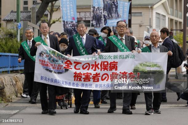 Unrecognized sufferers of the Minamata mercury-poisoning disease march to the Niigata District Court in Niigata, northwest of Tokyo, on April 18,...