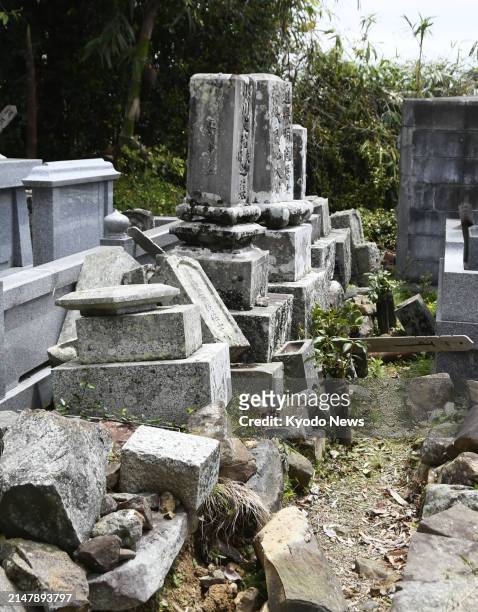 Photo taken April 18 shows collapsed tombstones in Ainan in Ehime Prefecture, western Japan, after an earthquake with a magnitude of 6.6 hit a wide...