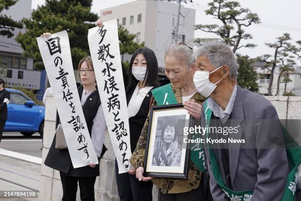 Unrecognized sufferers of the Minamata mercury-poisoning disease and their lawyers meet the media outside the Niigata District Court in Niigata,...