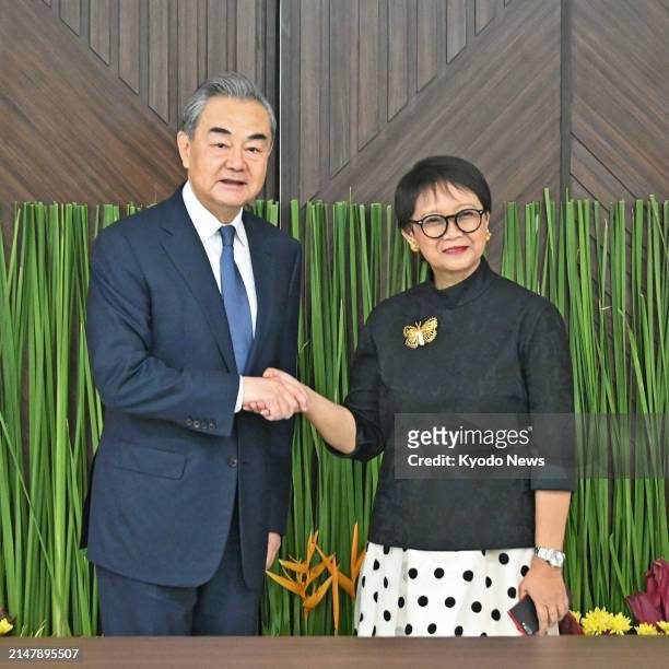 Chinese Foreign Minister Wang Yi shakes hands with his Indonesian counterpart Retno Marsudi on in Jakarta on April 18, 2024.