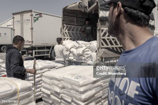 Workers unload and pack donated flour directed to Gaza inside a warehouse of the Jordan Hashemite Charity Organization in Amman, Jordan, on...