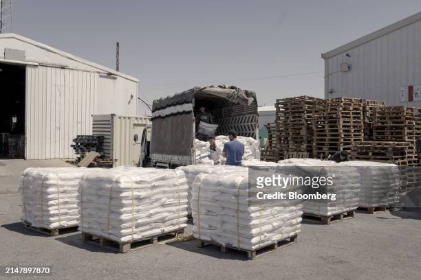 Workers prepare sacks of flour as part of a humanitarian aid shipment to the Gaza Strip at a warehouse operated by the Jordan Hashemite Charity...