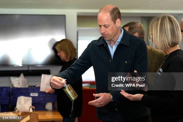 Prince William, Prince of Wales is shown items by Claire Hopkins, Operations Director, right, during a visit to Surplus to Supper, in...