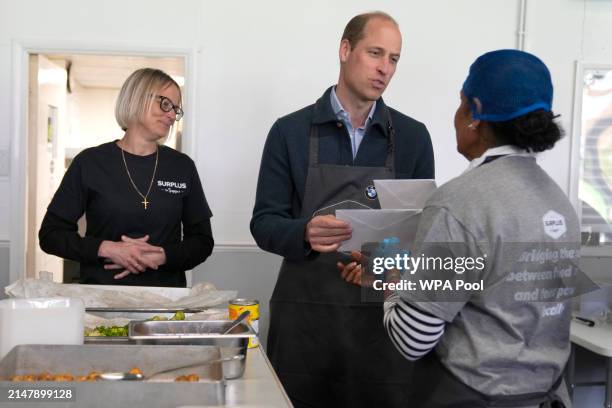 Prince William, Prince of Wales is given cards for his wife Catherine, Princess of Wales by volunteer Rachel Candappa as Claire Hopkins, Operations...
