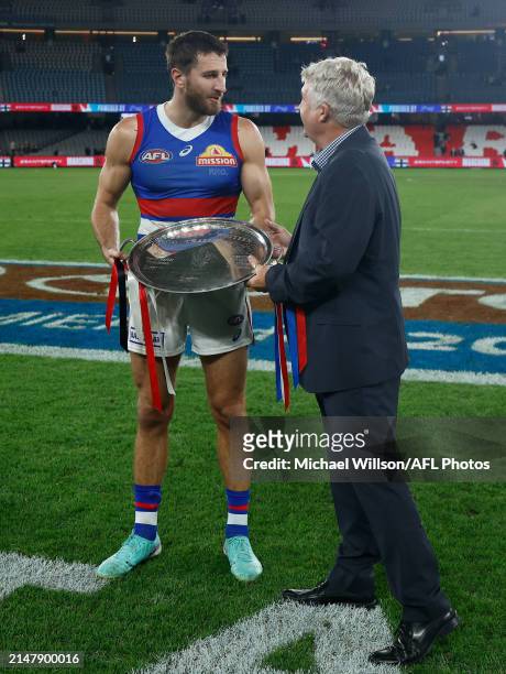 Marcus Bontempelli of the Bulldogs is presented with the Barker-Whitten Challenge Plate by Challenge CEO David Rogers during the 2024 AFL Round 06...