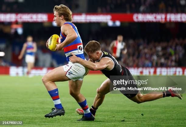 Ryley Sanders of the Bulldogs is tackled by Sebastian Ross of the Saints during the 2024 AFL Round 06 match between the St Kilda Saints and the...