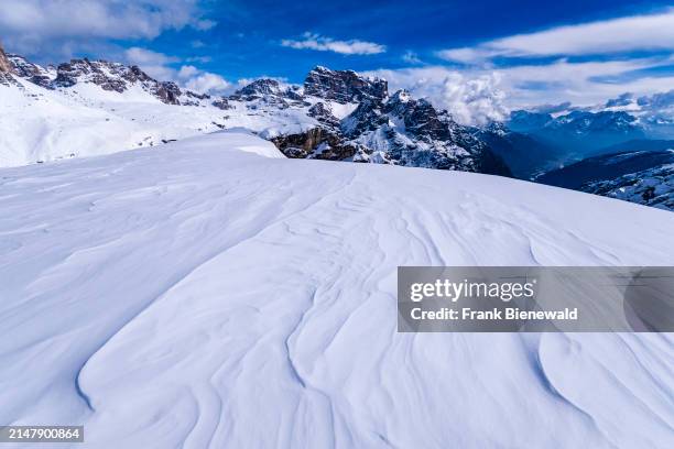 Snowdrift creating artful structures in Tre Cime Natural Park in winter, the summit of Croda dei Toni in the distance, seen from Monte Campedele. The...