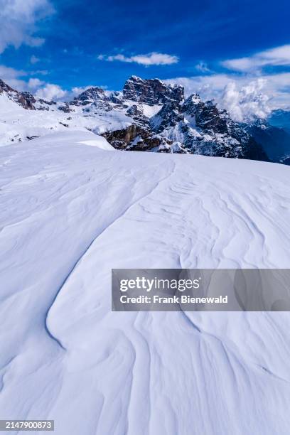 Snowdrift creating artful structures in Tre Cime Natural Park in winter, the summit of Croda dei Toni in the distance, seen from Monte Campedele. The...