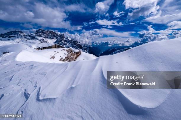 Snowdrift creating artful structures in Tre Cime Natural Park in winter, the summit of Croda dei Toni in the distance, seen from Monte Campedele. The...