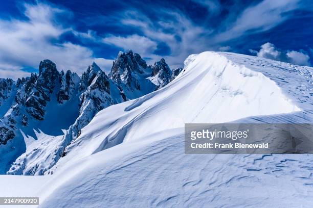 Snowdrift creating artful structures in Tre Cime Natural Park in winter, the summits of Cadini di Misurina in the distance, seen from Monte...