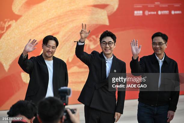 Chinese actor Dong Chengpeng and Hong Kong film director Stanley Kwan Kam-Pang arrive on the red carpet during the opening ceremony of the 14th...