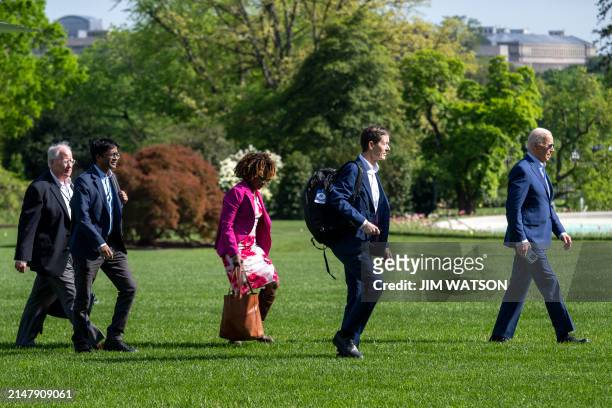President Joe Biden walks with staff on the South Lawn upon returning to the White House in Washington, DC, on April 18, 2024. Biden is returning...