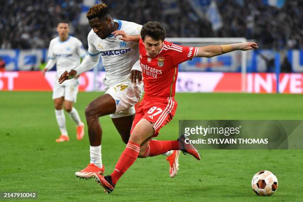 Marseille's Cameroonian forward Faris Moumbagna fights for the ball with Benfica's Portuguese midfielder Joao Neves during the UEFA Europa League...