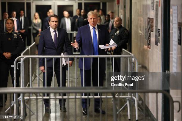 Former US President Donald Trump holds news clippings as he leaves court for the day at Manhattan Criminal Court on April 18, 2024 in New York City....