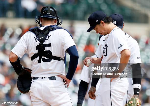 Kenta Maeda of the Detroit Tigers and catcher Carson Kelly of the Detroit Tigers wait for a visit from the pitching coach during a game against the...