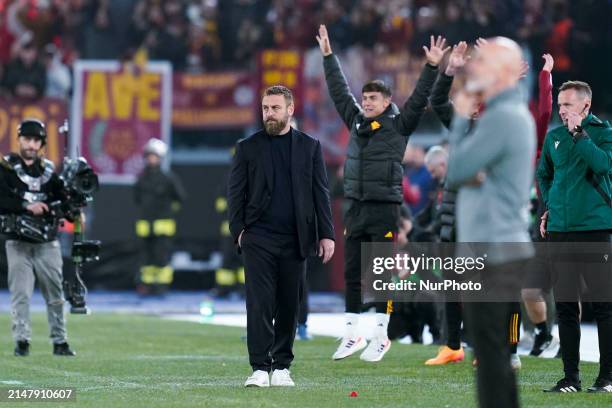 Daniele De Rossi head coach of AS Roma looks on while Paulo Dybala of AS Roma jumps behind him to celebrate the victory during the UEFA Europa League...