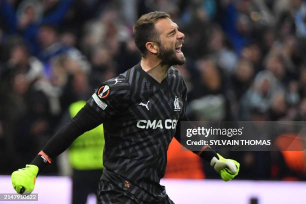 Marseille's Spanish goalkeeper Pau Lopez reacts after stopping a shot during the penalty shoot out during the UEFA Europa League quarter final second...