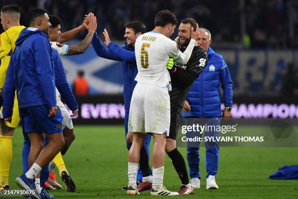 Marseille's Italian Argentinian defender Leonardo Balerdi celebrates with Marseille's Spanish goalkeeper Pau Lopez and Marseille players and staff...